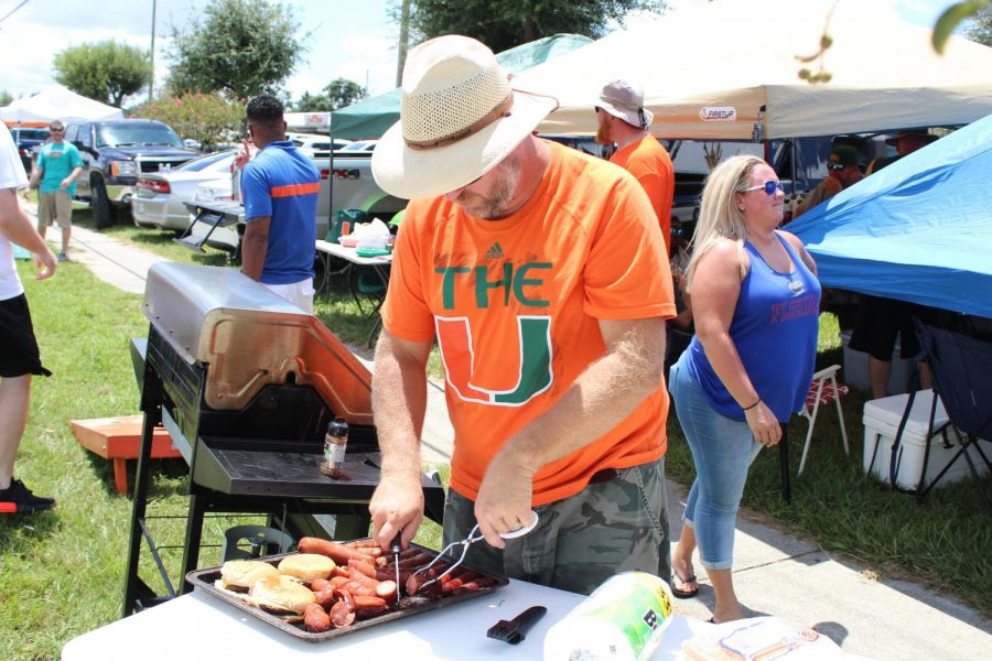Trent Hopper prepares food during the tailgate.