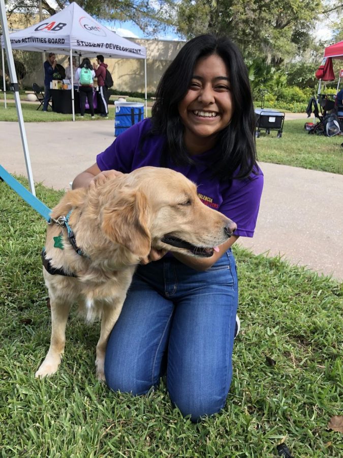  Dayane Villatoro greeting an emotional support dog during FallOh Your Path’s 2019 stress relief event. 
