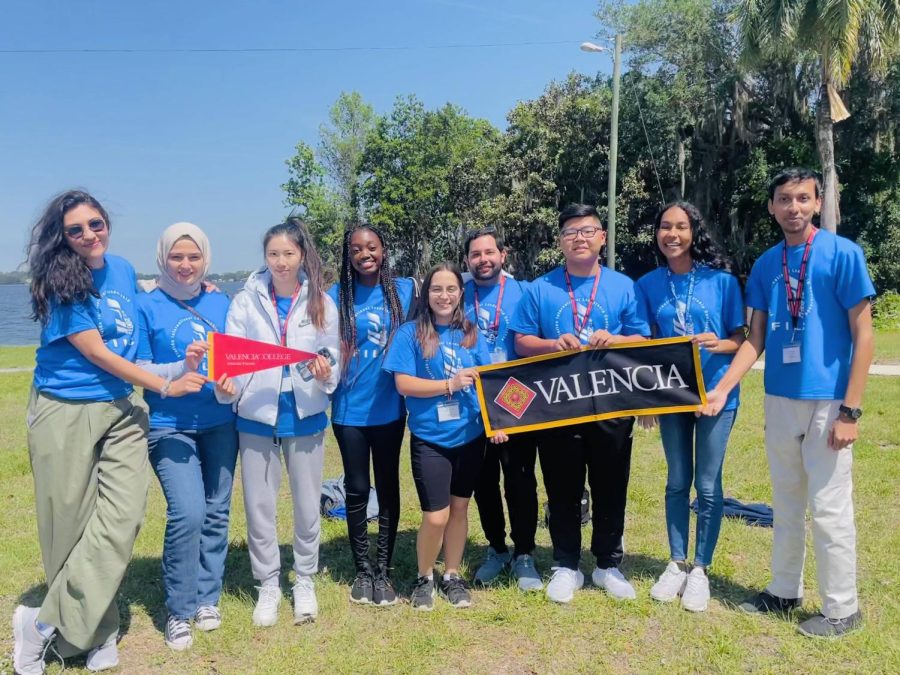 Valencia students pose with the Valencia College banner. 