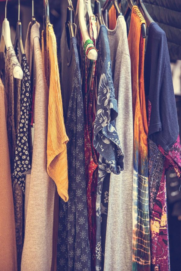 Image of a thrift shop boutique selection of shirts and other clothing. 