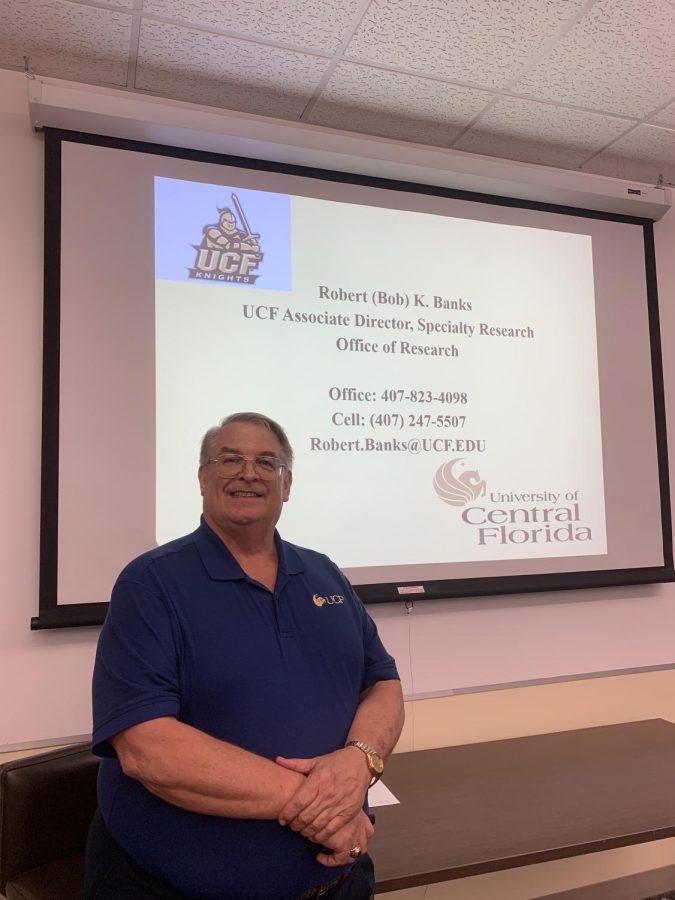 UCF Office of Research Associate Director Robert Banks stands in front of his presentation on STEM, life and his progress through an education and career. 