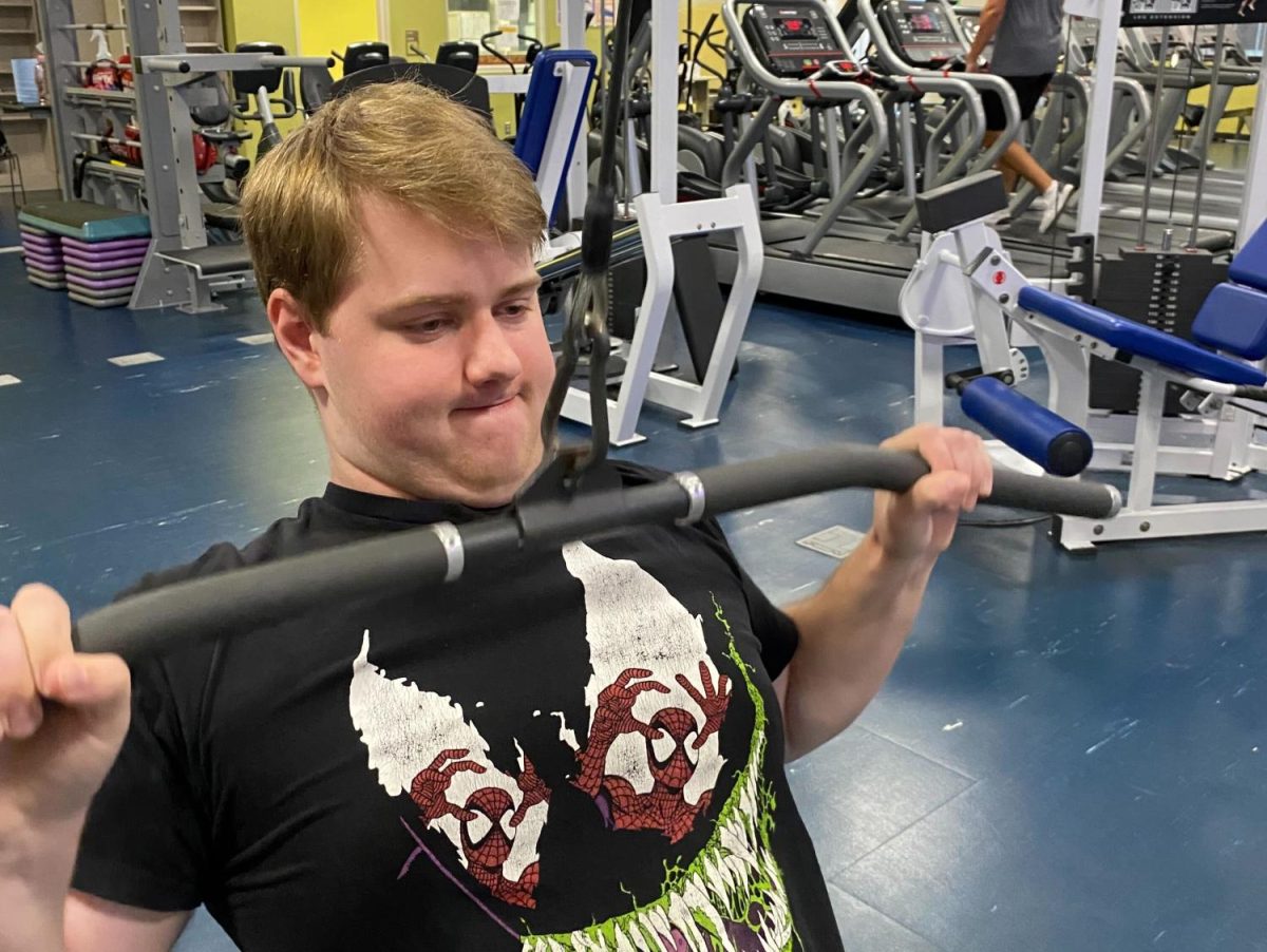 Max Cook, 22, demonstrates using the Lat Pulldown machine. Cook says he works out to look good and enjoys using the Fitness Center for their accessibility and positive environment.  