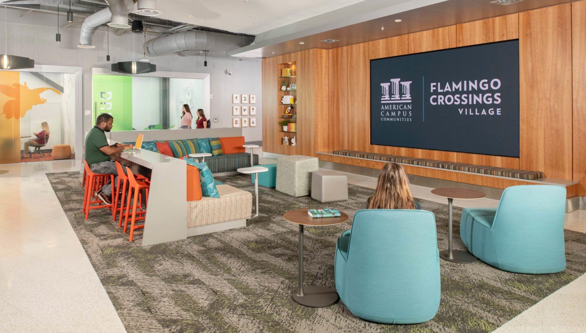Flamingo Crossings Village lobby with large television display and open seating area. 