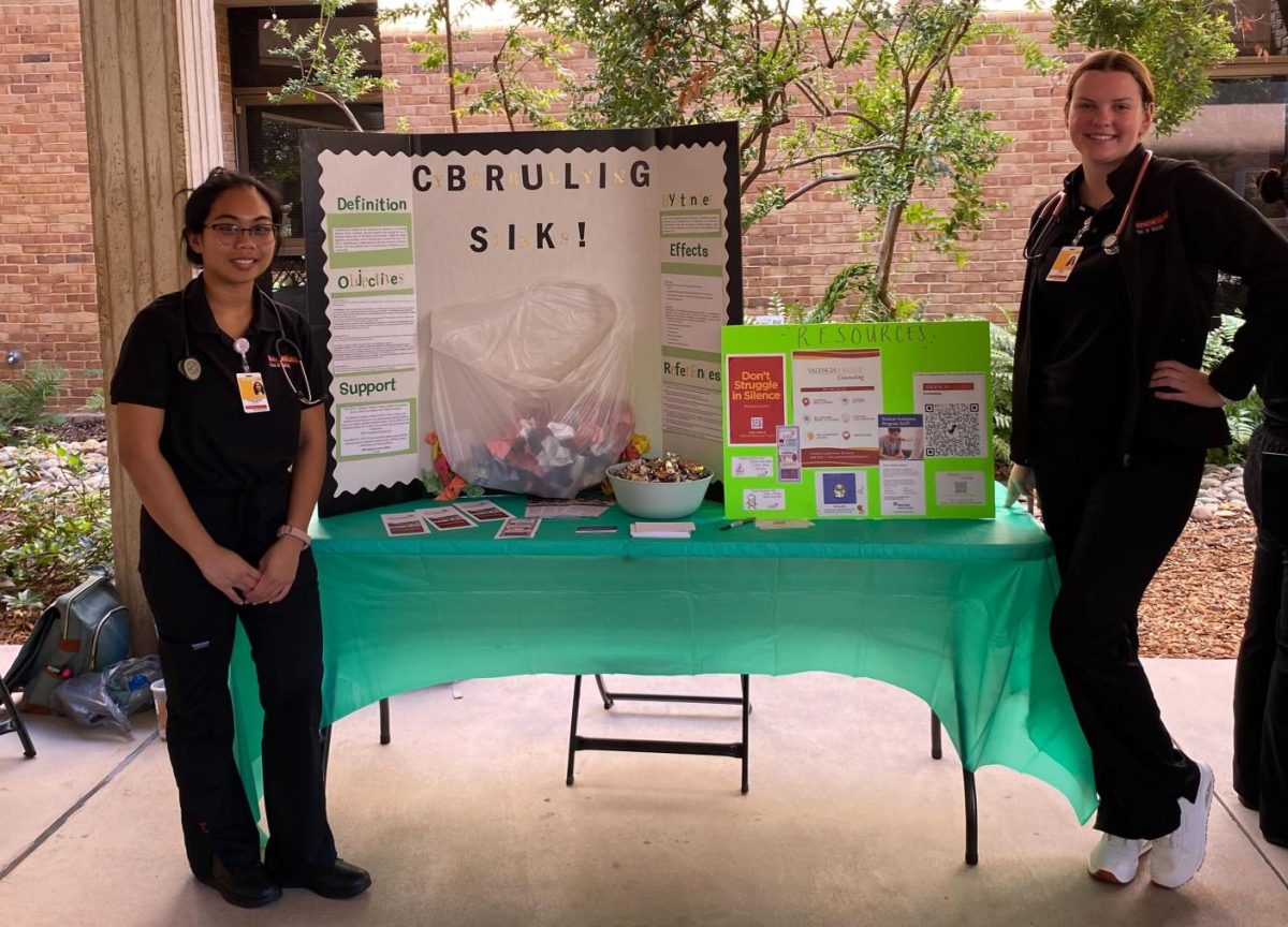 Nursing students Hazel Medina (left)  
and Riley Lang (right) discuss cyberbullying with West Campus students through their visual display on October 16. 