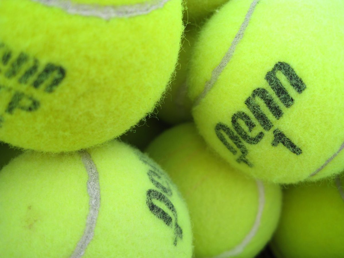 Image depicts close-up of green tennis balls in a pile. CC2.0 by Flickr user