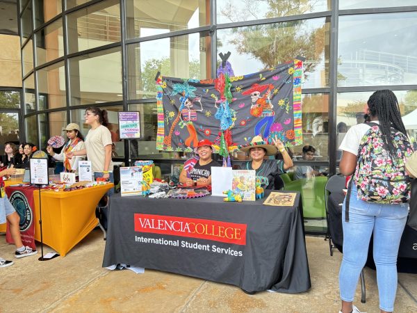 Natalie Munoz, 30, and her colleague give a welcoming smile to the students at the East Campus Fiesta de Musica
while sharing information about their services.
