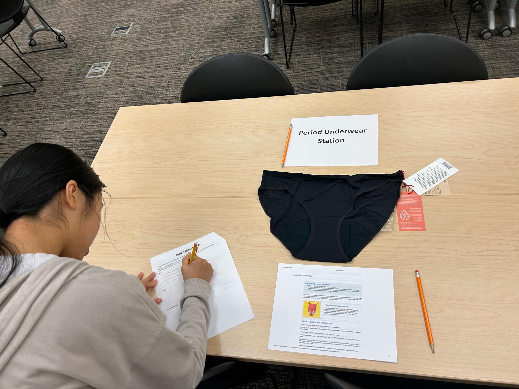 Valencia College student, Yanhua Zhen, examines eco-friendly options at the period underwear station during the period alternatives workshop.